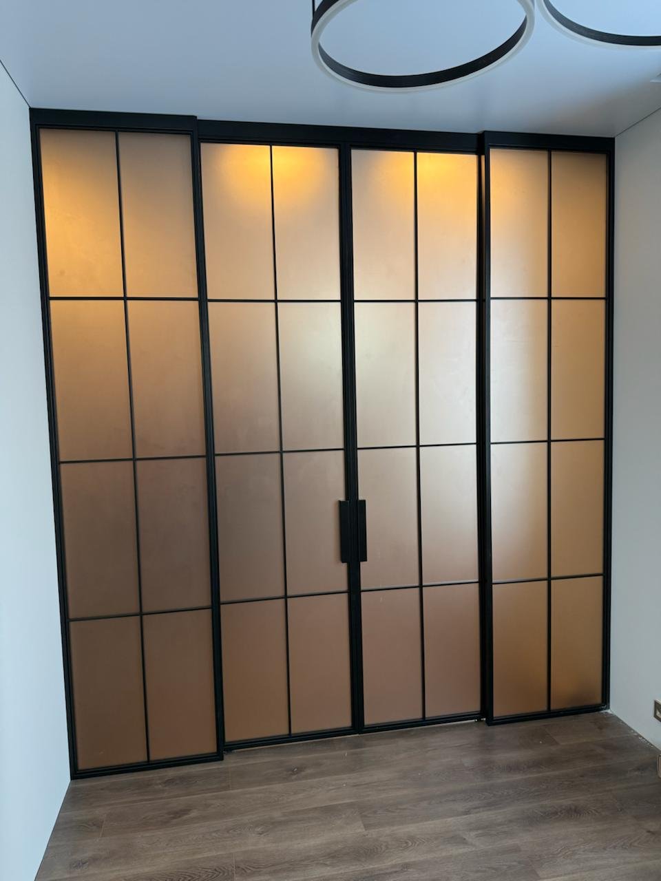 Puerta corrediza colgante sobre panel fijo en oficina gerencial